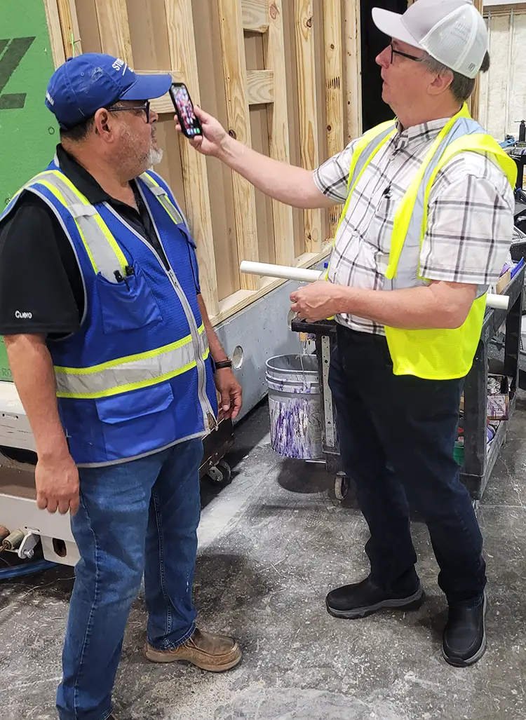Two men standing and discussing labor, flow and more on the floor